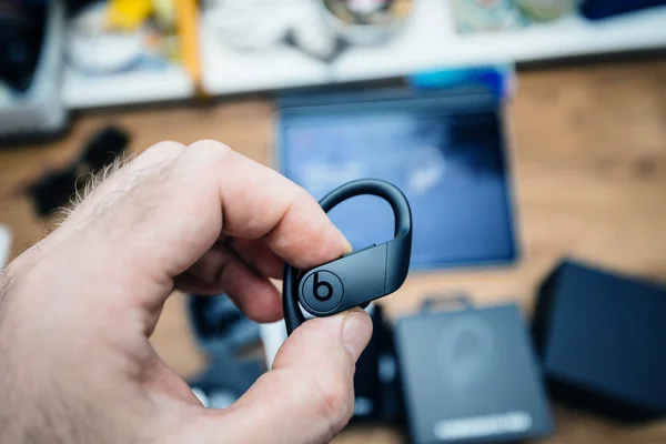 Mužovou ruku držící sluchátka powerbije pro s logotypem insignie — Stock fotografie