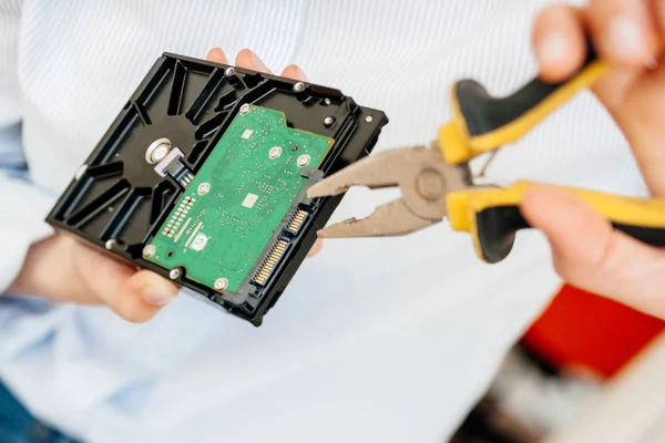 Female IT computer repair IT woman using yellow metal pliers — Stock Photo, Image