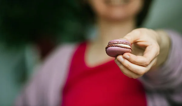 French woman showing delicious French sweet macaron