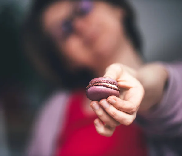 French woman showing delicious French sweet macaron