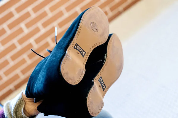 Woman hand holding pair of new Camper shoes — Stock Photo, Image