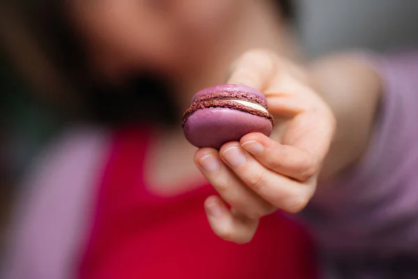 French woman showing delicious French sweet macaron