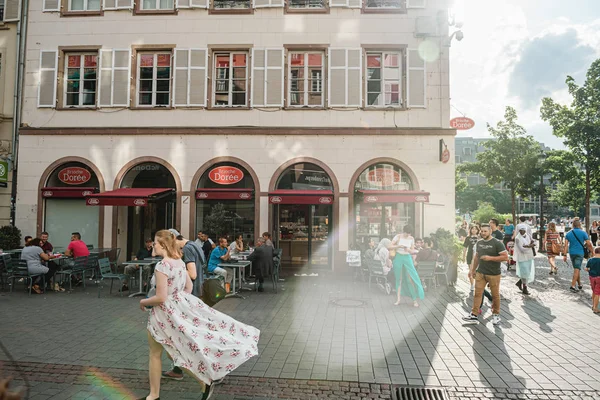 Young woman with wavy floral dress walking on street — Stock Photo, Image