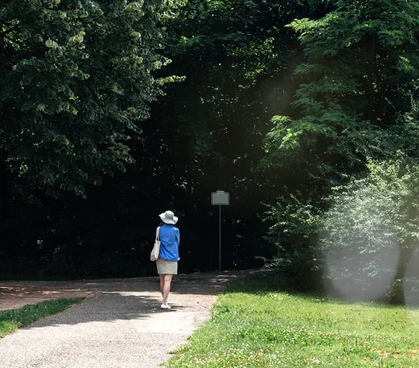 Woman walking into forest — Stock Photo, Image