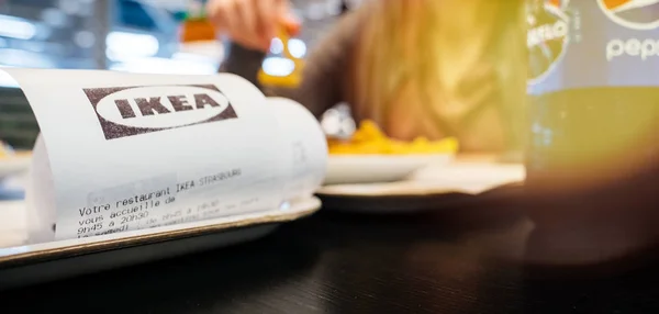 IKEA kertas penerimaan sebagai wanita makan di dalam makanan IKEA — Stok Foto
