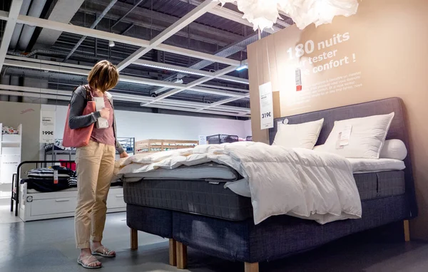 Mujer mirando edredón de cama elegir ropa de cama — Foto de Stock