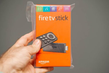 Adam yeni Firetv Stick ile el paketi tutarak