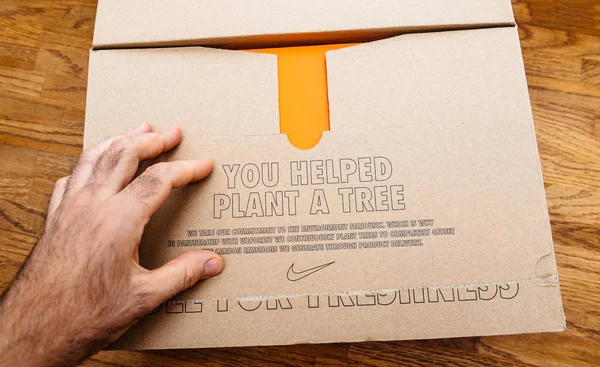 Paris france - 13. jul 2019: oben anzeigen auspacken sport laufschuhe ausrüstung hergestellt von u nike sportswear umweltbotschaft du hast geholfen einen baum zu pflanzen — Stockbild Sie halfen beim Pflanzen einer Baumnike-Pappe — Stockfoto