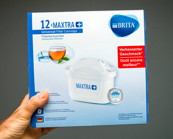 Человек держит новый картридж фильтра воды Brita
