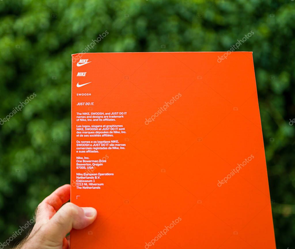 Paris France - Jul 13 2019: Man hand holding new Nike running shoes equipment cardboard box manufactured by Nike sportswear - side view of the box with logotypes Jus Do It