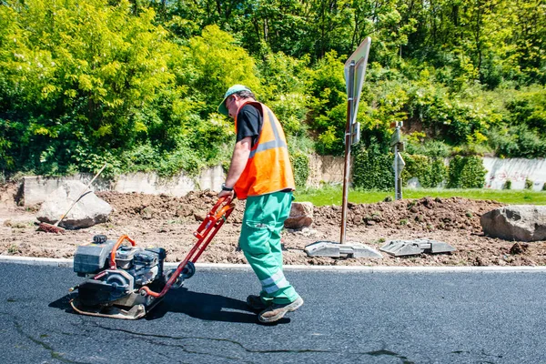 Male worker working with industrial hand tool asphalt posing — Stock Photo, Image