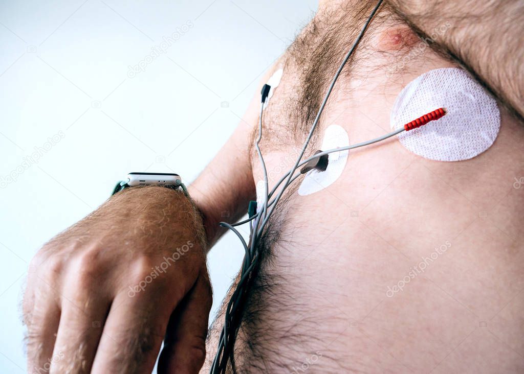 Man setting smartwatch wearing a heart monitor holter