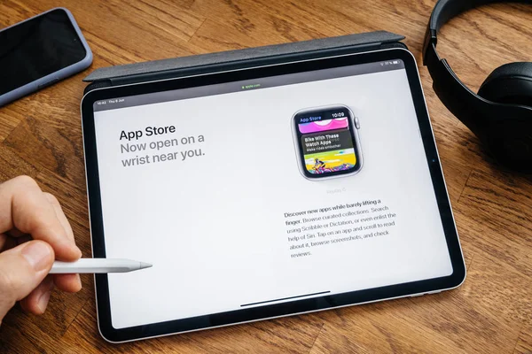 Člověk čte na zařízení iPad pro o aplikaci Store v sledování 4 — Stock fotografie
