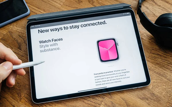 Hombre leyendo en el iPad Pro nuevas caras del reloj —  Fotos de Stock