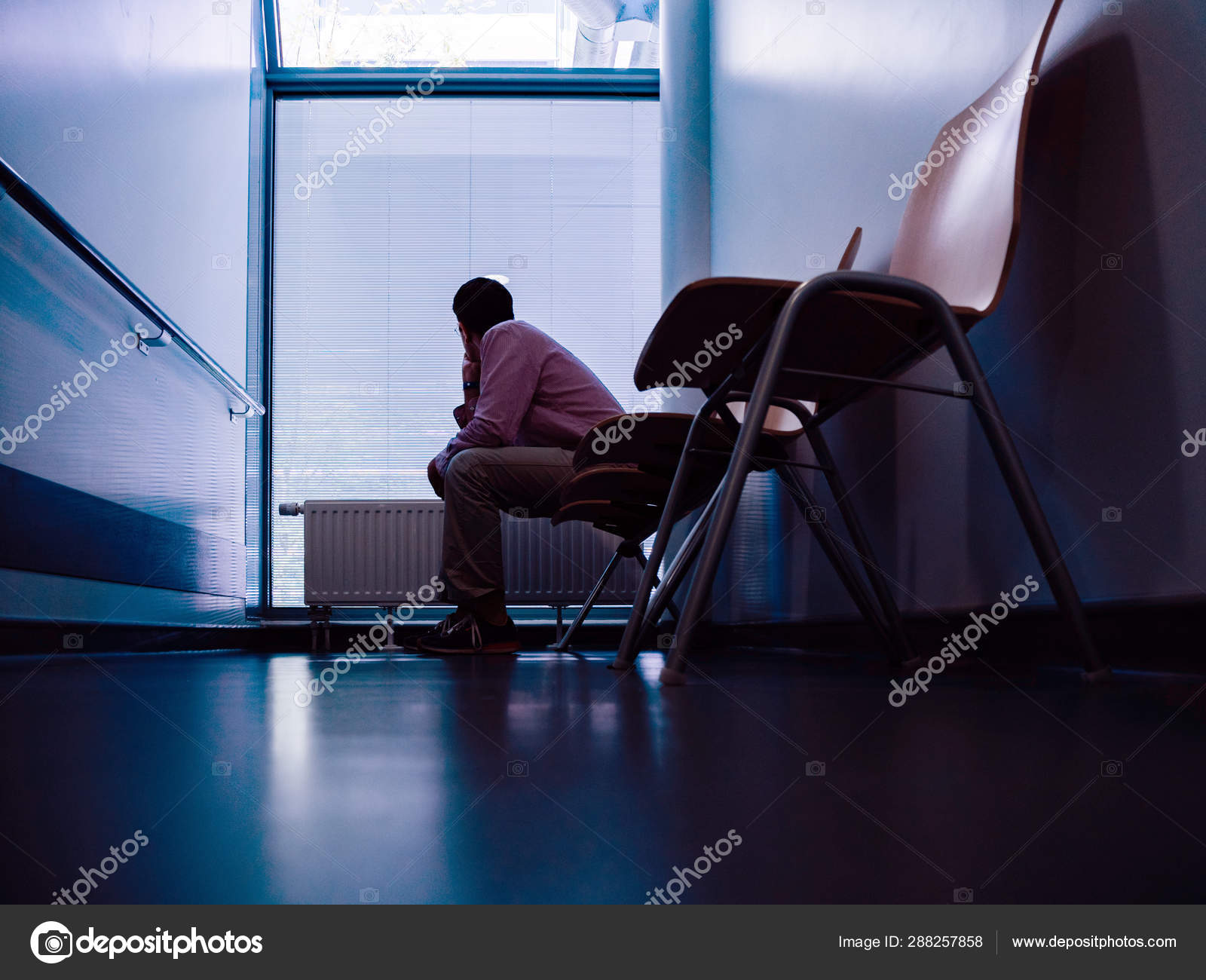 Lonely Patient Sitting In Modern Hospital Waiting Lobby