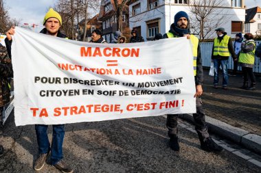 Emmanuel Macron karşı rozetleri ile yürüyüş protestocular
