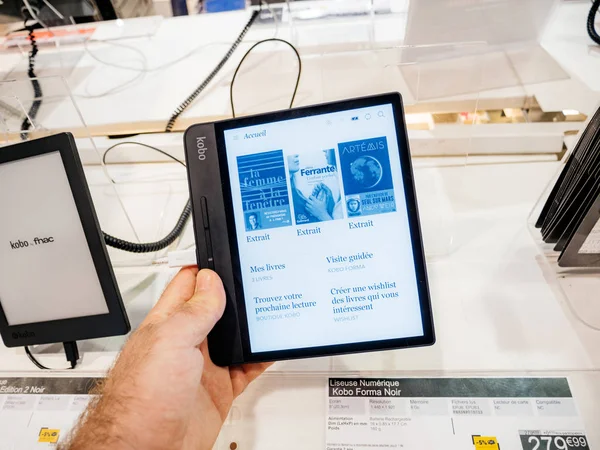 Uomo mano che tiene Kobo Forma e-reader libro in Fnac — Foto Stock