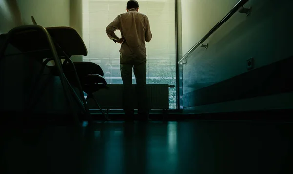 Uomo che utilizza lo smartphone in sala d'attesa dell'ospedale — Foto Stock