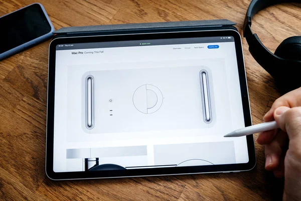 Человек, читающий на iPad Pro, запускает рабочую станцию Mac Pro — стоковое фото