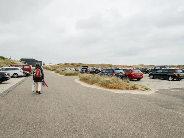 Woman walking in parking Dutch beach — Stock Photo, Image