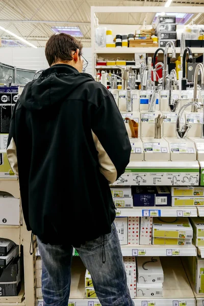 DIY店で蛇口を買い物する男の背面図 — ストック写真