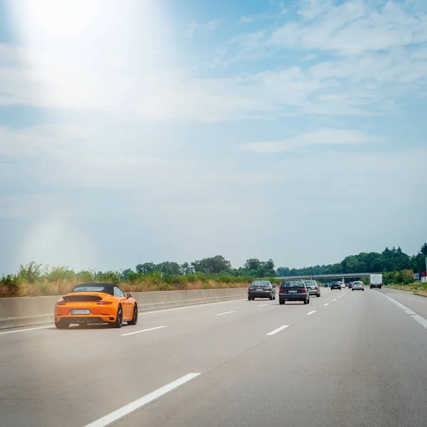 Widok z tyłu szybko nowego pomarańczowego Porsche 911 samochód sportowy — Zdjęcie stockowe