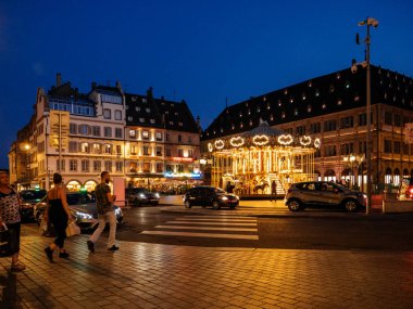 Place Gutenberg'de alacakaranlıkta yürüyen yayalar