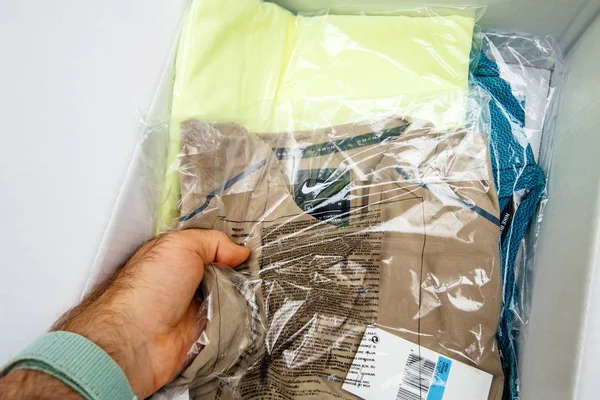 Homem mão unboxing desembalagem Nike Sport roupas — Fotografia de Stock