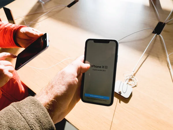 Man en vrouw handen houden nieuwste iPhone XR smartphone — Stockfoto