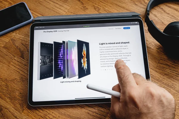 Man reading on iPad Pro about Pro Display XDR — Stock Photo, Image
