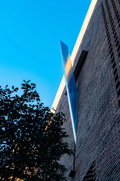 Cruz de metal abstrato na fachada de tijolo de parede — Fotografia de Stock