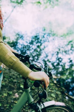 Su önünde bisiklet sapı tutan kadın