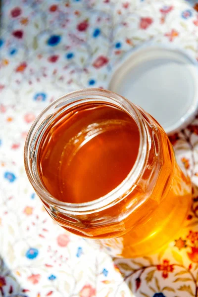 Tarro abierto con miel bio orgánica amarilla fresca — Foto de Stock