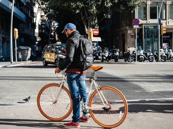 Beyaz turuncu bisiklet yanında genç adamın yan görünümü