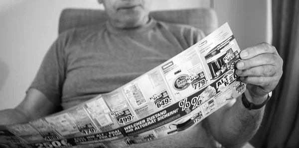 Άτομο που κατέχει διαφημιστικά Φέιγ βολάν με ανάγνωση για νέα οικιακά προϊόντα — Φωτογραφία Αρχείου
