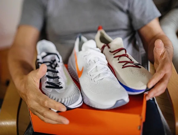 Tilt-shift foto de hombre mayor feliz unboxing zapatos Nike —  Fotos de Stock