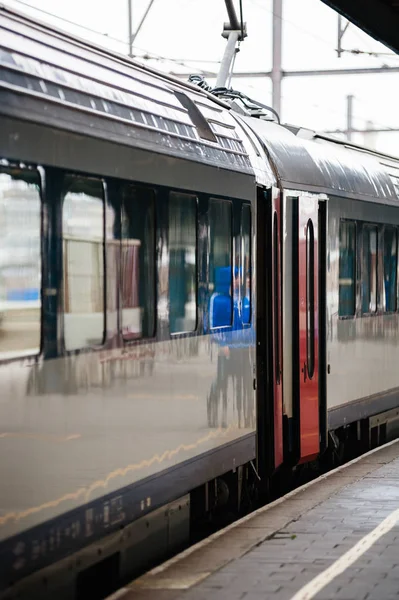 Train with open doors on railway station platform