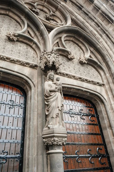 Mayo sosteniendo la estatua de Jesús sobre la entrada de la Iglesia Neogótica — Foto de Stock