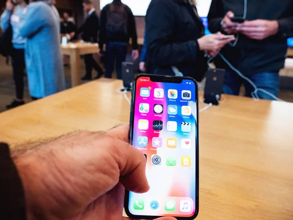 Hand admiring inside Apple Store the latest professional iPhone — Stock Photo, Image