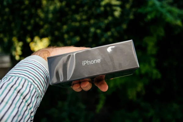 Mano del hombre sosteniendo el nuevo teléfono inteligente iPhpone 11 Pro de cartón — Foto de Stock