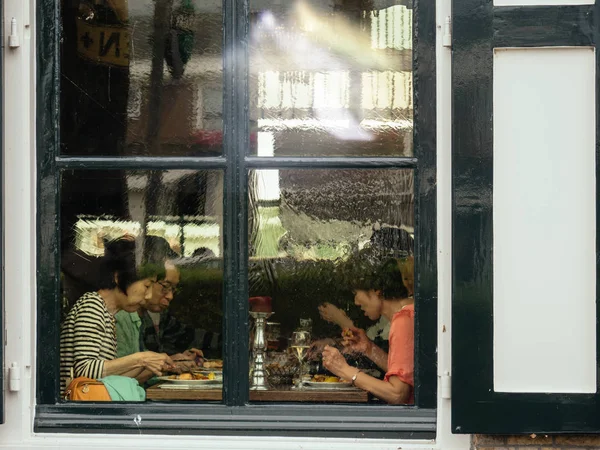 Chinese asian tourists eating in Dutch restaurant — Stock Photo, Image