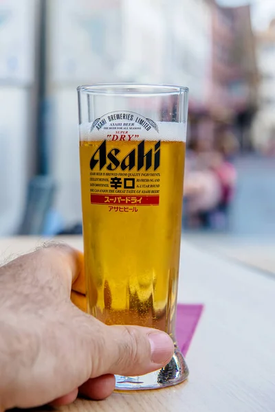 Mano sosteniendo la tradicional cerveza de vidrio Asahi — Foto de Stock