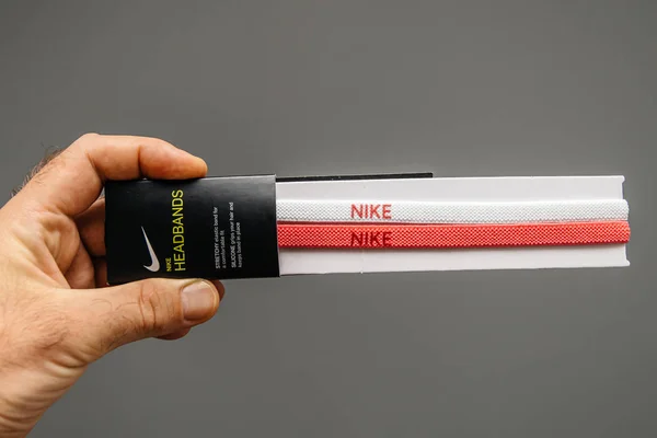 En hand som håller ett par nya Nike pannband — Stockfoto