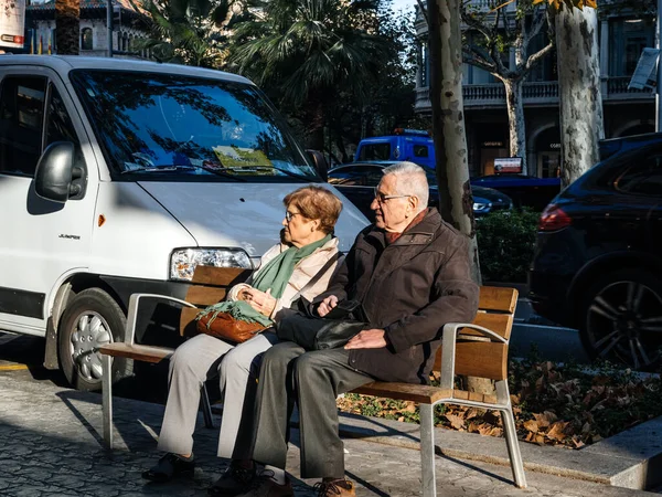 Pareja mayor descansando en la silla pública Barcelona — Foto de Stock