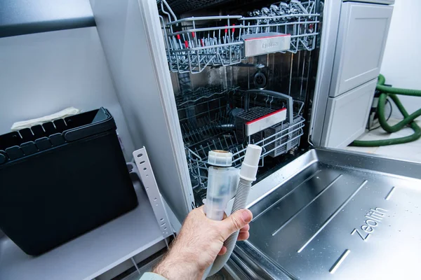 Installer male hand holding tubes from the dishwashing machine with Zeolith system — Stock Photo, Image