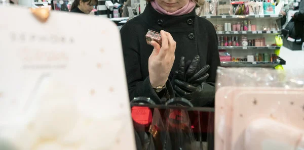 Defocused silhuetter af kvinde shopping for moderne luksus kosmetik - Stock-foto