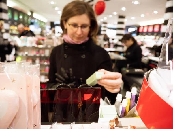 Silhuetas desfocadas de mulher comprando cosméticos de luxo modernos — Fotografia de Stock