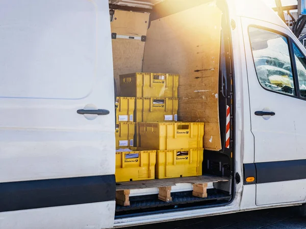 Вид сбоку на фургон доставки посылки с желтыми коробками с буквами и картонными посылками — стоковое фото