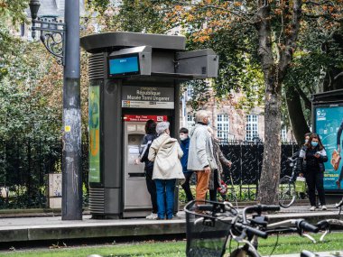 Cumhuriyet tramvay istasyonunda koruyucu maske takan insanlar.