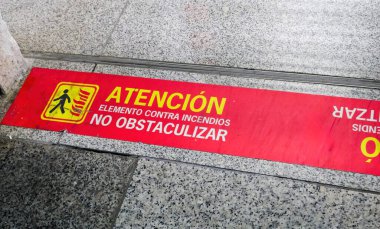 Kırmızı İspanyol güvenlik zemini, Palma de Mallorca havalimanı içindeki granit fayansların üzerindeki dikkat sembolü ile ateş elementinin engellenmesine karşı uyarıda bulundu